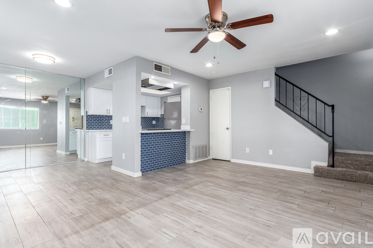 A spacious living room with a staircase leading to the upper floor.