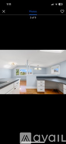 A kitchen with white cabinets and a window.