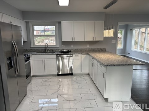 A kitchen with white cabinets and a granite countertop.