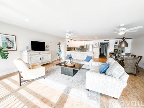 A living room with a white chair and a white sofa.