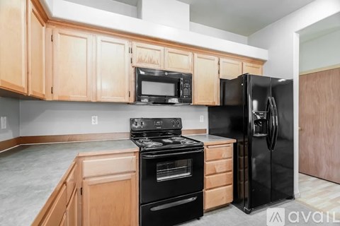 A kitchen with wooden cabinets and black appliances.