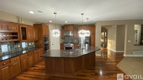 A modern kitchen with wooden cabinets and a central island.