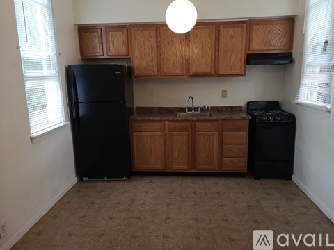 A kitchen with wooden cabinets and black appliances.