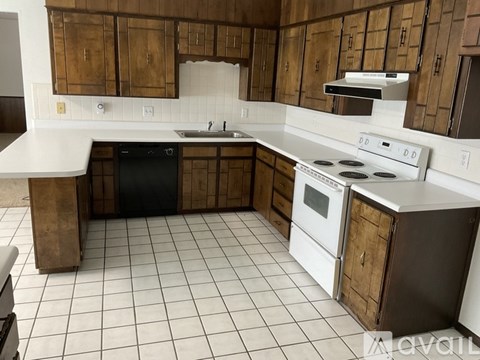 A kitchen with white appliances and brown cabinets.