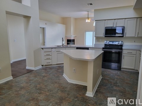A kitchen with a granite countertop and a stove top oven.