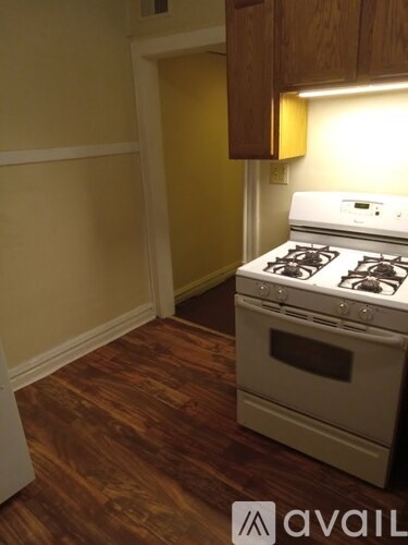 A white stove in a kitchen with wooden floors.