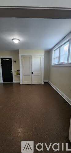 A room with brown flooring and a white door.
