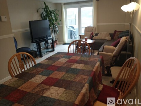 A living room with a quilt on the table and chairs.