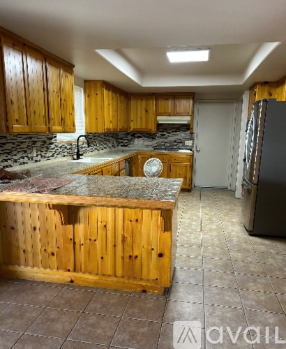 A kitchen with wooden cabinets and a granite countertop.
