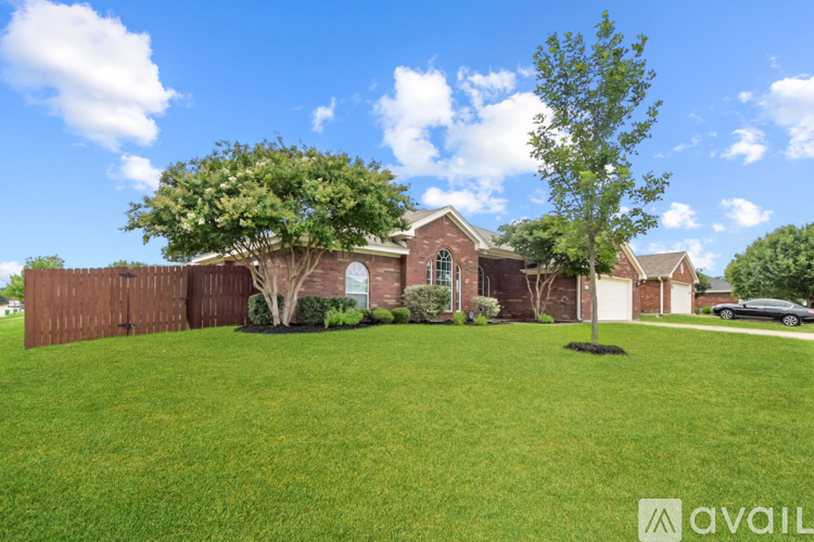 A house with a brown fence and a tree in front.