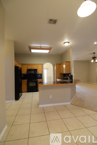 A spacious room with a chandelier, arched doorways, and a view of a garden through the windows.