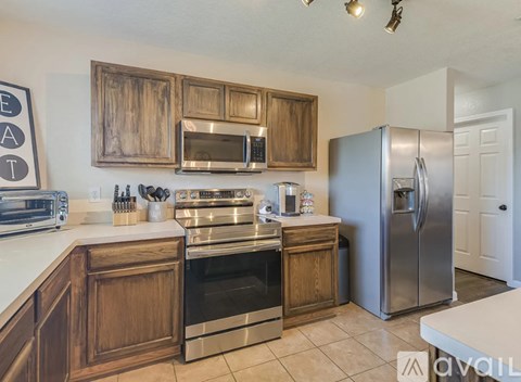 A kitchen with wooden cabinets and stainless steel appliances.