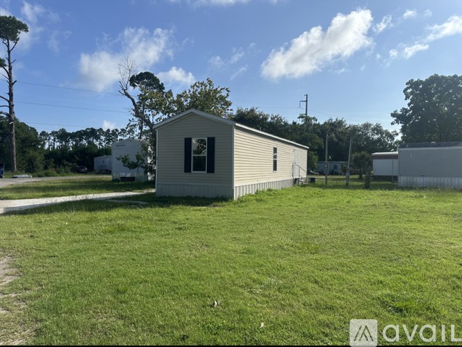 A small house with a green lawn in front of it.
