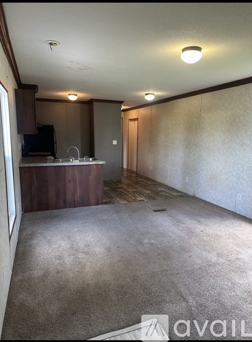 A room with a carpeted floor and a television set.