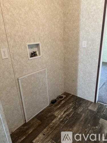 A room with a wooden floor and a wall with a window.