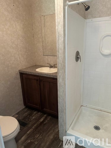 A bathroom with a toilet, sink, and shower.