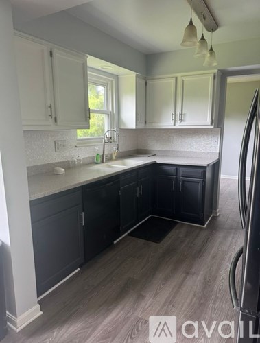 A kitchen with white cabinets and a sink.