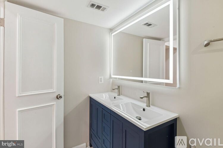A bathroom with a white sink and a mirror above it.