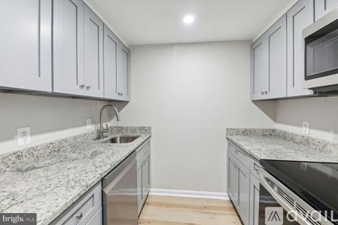 A kitchen with granite countertops and stainless steel appliances.