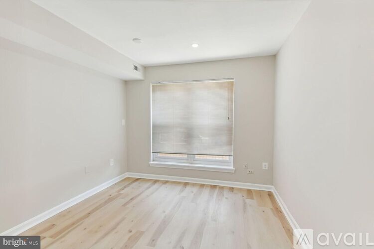 A room with a window and wooden flooring is available for rent.