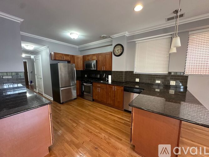 A kitchen with wooden floors and a refrigerator.