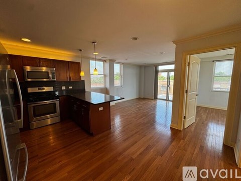 A room with wooden floors and a sliding glass door leading to a balcony.