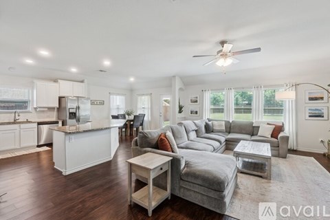 A spacious living room with a grey couch and a wooden coffee table.