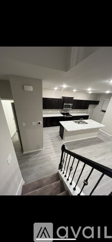 A well-lit, modern kitchen with a dining area and a staircase.