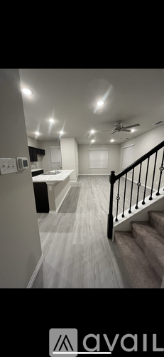 A well-lit, spacious room with a staircase leading to the upper floor.