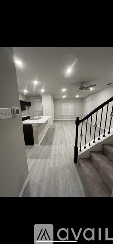 A well-lit, spacious room with a staircase leading to the upper floor.