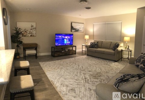 A living room with a television on a stand and a couch.