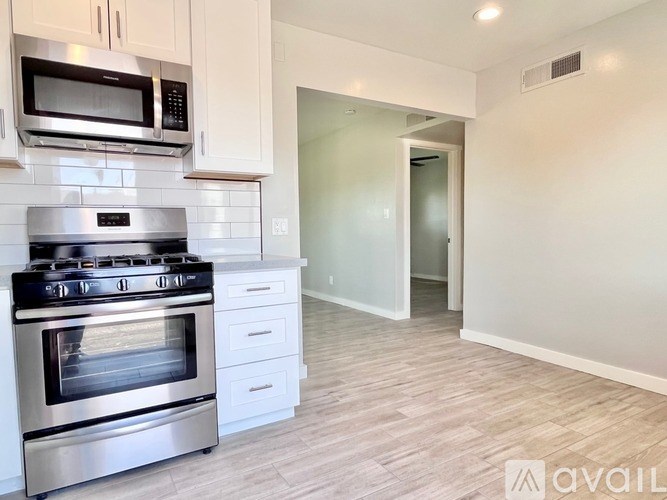 A kitchen with a stainless steel oven and microwave above it.