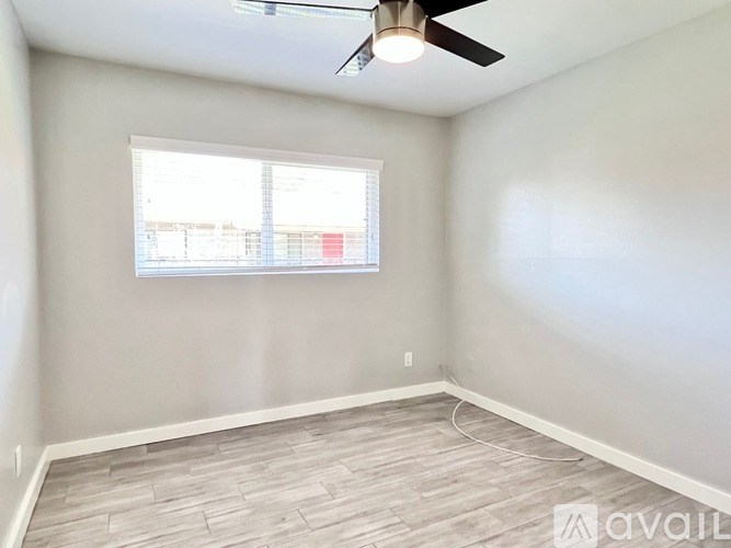 A room with a ceiling fan and a window.