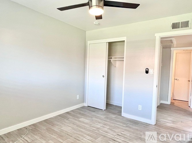 A room with a ceiling fan and two doors.