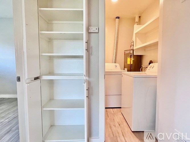 A white kitchen with a white fridge and a white door.