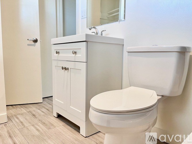 A white toilet sits next to a white sink in a bathroom.