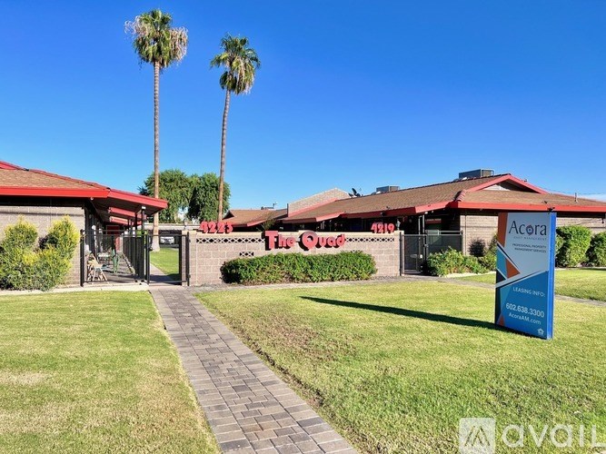 A sign for Acela in front of a building with a red roof.