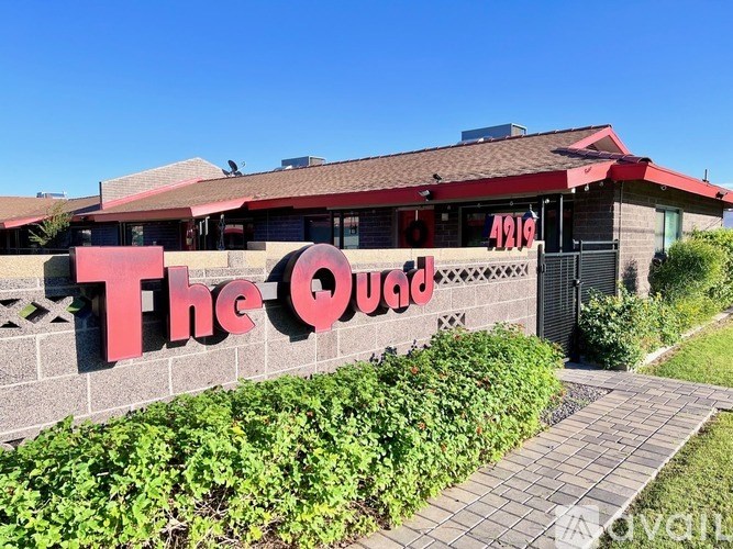 The Quad restaurant sign is displayed on a building.