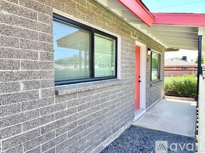 A brick house with a red door and a window.
