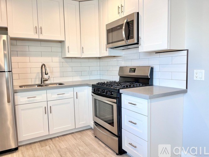 A kitchen with white cabinets and a black stove top.