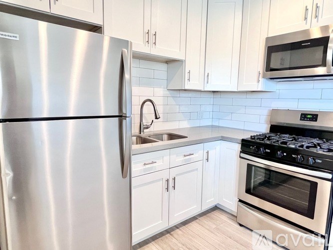 A kitchen with a stainless steel refrigerator, oven, and cabinets.