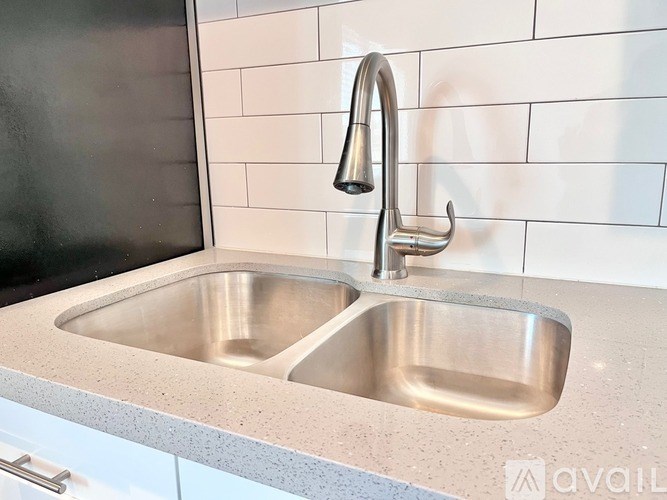 A modern kitchen sink with a chrome faucet.
