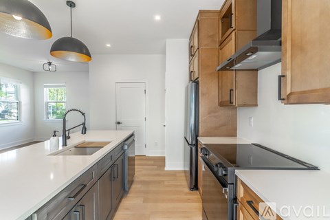 A kitchen with wooden cabinets and a black refrigerator.