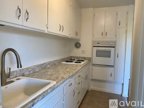 A kitchen with white cabinets and a granite countertop.