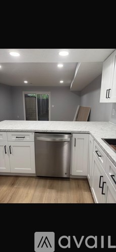 A kitchen with white cabinets and a stainless steel dishwasher.