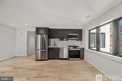 A kitchen with a stainless steel refrigerator, oven, and dishwasher.