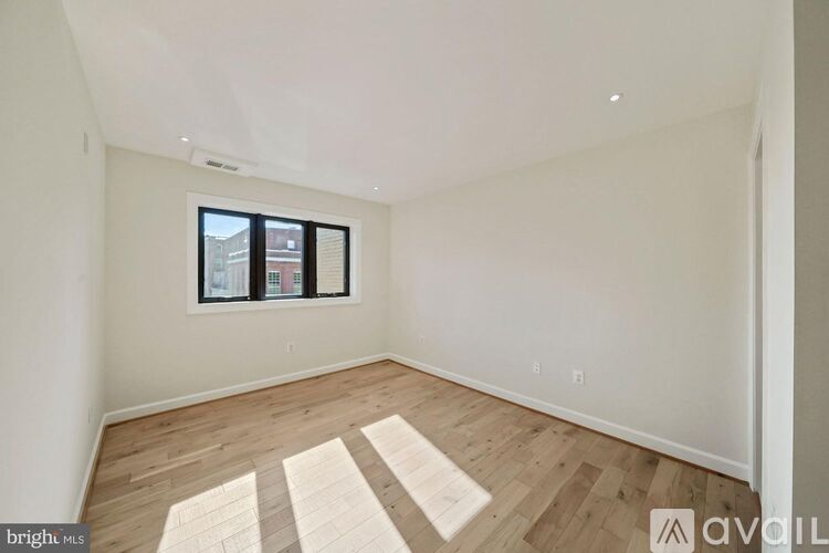 A room with wooden flooring and a window.