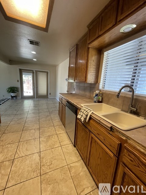 A kitchen with wooden cabinets and a tiled floor.