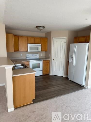 A kitchen with wooden cabinets and a white refrigerator.