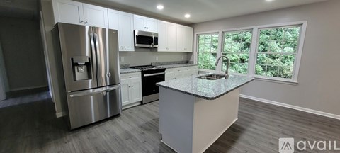 A kitchen with a stainless steel refrigerator, microwave, and dishwasher.
